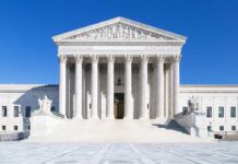 Congress Is Fighting Over A Surveillance Program That Can Sweep Up Americans’ Data The Supreme Court building featuring marble columns and a clear blue sky