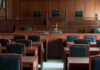 Hollywood Predator Stunned: Judge Must Re-Do Time Empty courtroom with wooden furnishings and judges bench.