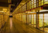 Prison Crisis Deal Lets Predators Walk Empty hallway between rows of prison cells.