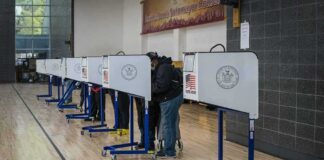 Voters at polling booths in a gymnasium