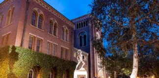 bronze athlete statue on campus at dusk