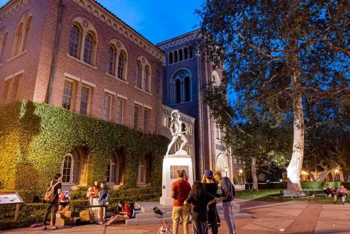 shutterstock_2125936307 bronze athlete statue on campus at dusk