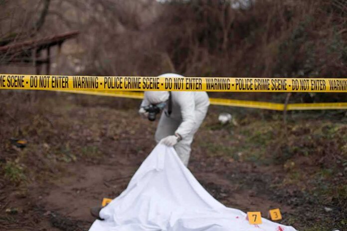 shutterstock_792627700 forensic investigator at outdoor crime scene behind caution tape