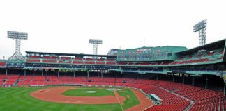 View of an empty Fenway Park baseball stadium with green grass and red seats