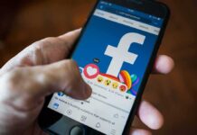 Texas Judge’s Facebook Fury Explodes Hand using smartphone with Facebook reactions on screen