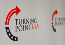 Campus Shuts Down. One Arena Doesn’t. Turning Point USA logo on a backdrop