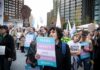 Protesters holding signs at a transgender rights rally