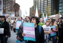 Protesters holding signs at a transgender rights rally