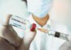 Fox Anchor’s Heart Scare After Vaccination Boosters Healthcare worker holds a COVID-19 vaccine vial and syringe