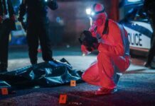 forensic investigator photographs crime scene evidence at night