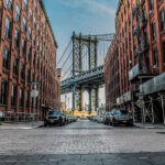 Rent Pain Sends Gen Z Down I-95 Street view with bridge between two brick buildings.