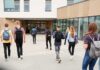 AI Perverts Target Schools — Blackmail Follows Students with backpacks walking toward a school entrance