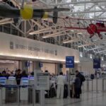 Armed Response Descends On Major U.S. Airport airport security checkpoint with passengers and hanging vintage airplanes