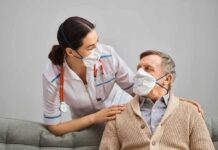 nurse with stethoscope comforting elderly man wearing masks