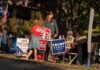Dirty Trick Backfires: Candidate Implodes People at a campaign booth with political signs outdoors