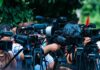 Trump’s Wild Pardon Sparks Justice Brawl TV news cameras crowding together at an outdoor event