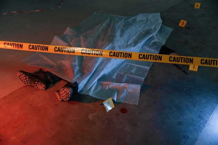 shutterstock_2245205881 crime scene body under sheet behind caution tape