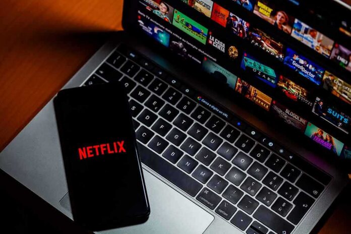 shutterstock_2307831607 Smartphone with Netflix logo on a laptop keyboard