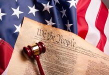 U.S. Constitution with gavel on American flag