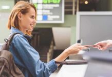 Woman at airport counter handing over passport