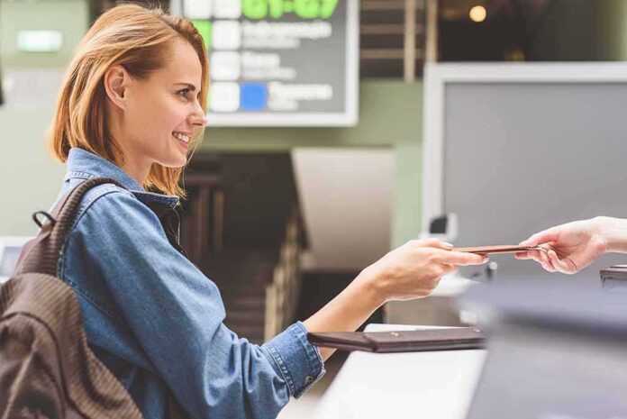Woman at airport counter handing over passport