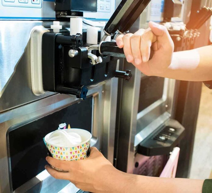 shutterstock_703813849 soft serve machine dispensing ice cream into a paper cup