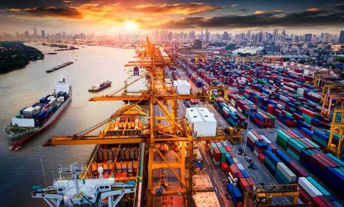 Container port with cranes and cargo ships at sunset