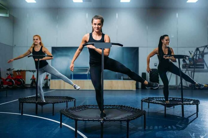 shutterstock_1059675206 Three women exercising on mini trampolines in a gym