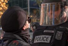 Metal Barricades, Hot Mics – Then The Push protester faces police officer in riot gear