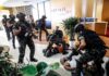 Tactical police detain suspects in an office lobby