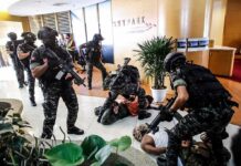 Church Funeral Massacre Shocks Jordan Tactical police detain suspects in an office lobby