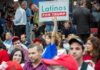 Historic Industrial Site Gets $3.7 Billion Comeback Child holding a 'Latinos for Trump' sign at a crowded rally