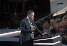 Peter Thiel speaking at a podium with microphones