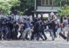 Protesters clash with riot police holding shields