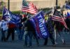 Kid Rock Ignites Clarksville – Crowd Erupts Crowd of people carrying political and American flags at a street gathering