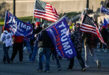 Kid Rock Ignites Clarksville – Crowd Erupts Crowd of people carrying political and American flags at a street gathering