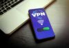 Smartphone showing VPN app beside a laptop