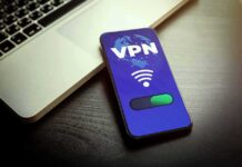 Smartphone showing VPN app beside a laptop