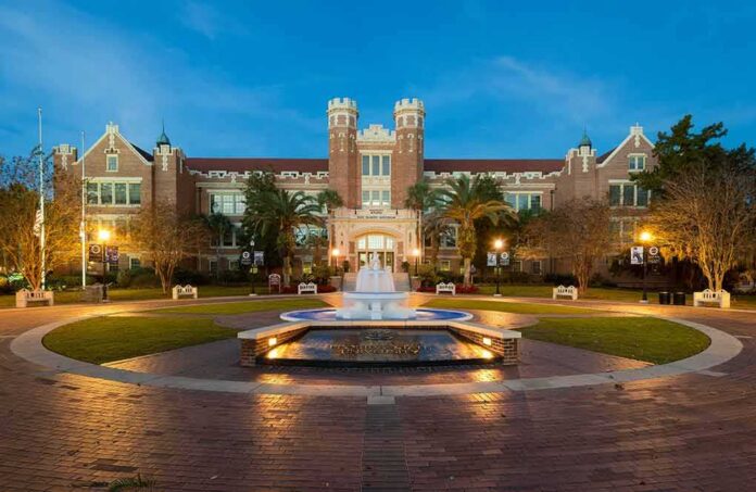 Historic brick university building with central fountain at dusk