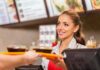 Ozempic Kills Supersize – Menus Shrink Fast Smiling cashier handing food trays to a customer