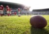 American football on a grass field at a stadium