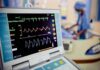 Patient monitor displaying vital signs in a hospital room