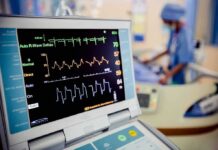 Patient monitor displaying vital signs in a hospital room