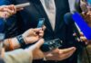 Cult Dinner Ends With Chilling Ultimatum businessperson in suit surrounded by microphones and recorders