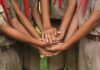 Teen Dies After Explosion Rocks School Field Trip scouts stacking hands in a teamwork huddle