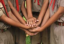 Teen Dies After Explosion Rocks School Field Trip scouts stacking hands in a teamwork huddle