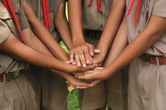 shutterstock_522627778 scouts stacking hands in a teamwork huddle