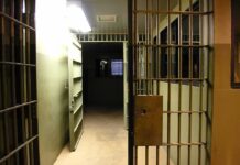 Prison corridor with open barred cell doors